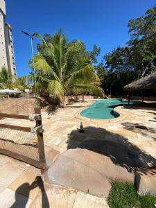 ośrodek z zielonym basenem i palmami w obiekcie Thermas do Bosque - Apt 311 w mieście Caldas Novas