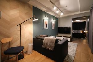 uma sala de estar com um sofá e uma televisão em Glass Shiseikan em Sapporo
