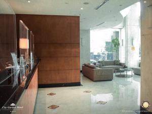 a lobby of a building with a couch and a table at City Garden Hotel Makati in Manila