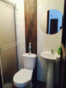 a bathroom with a toilet and a sink and a mirror at Casa Helga a dos cuadras de la Basílica, casa entera con jardín amplio, 6 habitaciones, 5 baños, cocina, comedor y sala de TV in Buga +10 photos