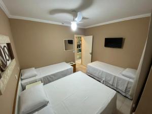 een kleine kamer met 2 bedden en een televisie bij Flat Riviera de São Lourenço in Riviera de São Lourenço +22 foto's