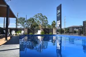 a swimming pool with blue water in front of a building at Orana Motel in Dubbo