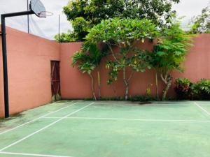 una pista de tenis con una valla y algunos árboles en KoolKost Syariah @ Jalan Cangkringan Kaliurang, en Kentisari