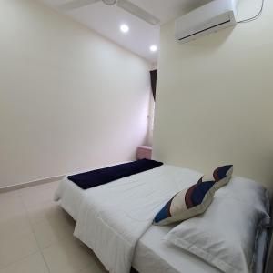 um quarto com uma cama num quarto branco em Homestay by NAF em Kuantan