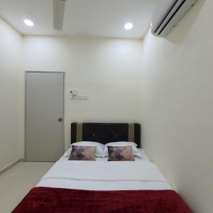 ein Schlafzimmer mit einem großen Bett mit zwei Kissen in der Unterkunft Homestay by NAF in Kuantan