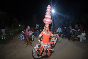 a woman is riding a wheelbarrow with bottles on her head at Pushkar Adventure Camp And Camel Safari in Pushkar