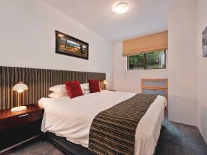 a bedroom with a large white bed with red pillows at Lantern 2 bedroom Terrace with panoramic mountain view in Thredbo