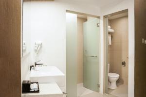 ASTON Kemayoran City Hotel في جاكرتا: حمام مع حوض ومرحاض