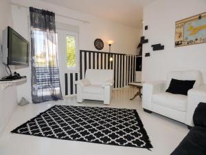sala de estar con 2 sillas blancas y alfombra en Apartment Eneja en Rab