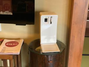 un secador de pelo blanco sobre una mesa en Minshuku Kuwataniya, en Takayama