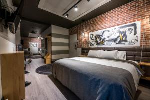 a bedroom with a large bed and a brick wall at La Suite Hébergements in Shawinigan