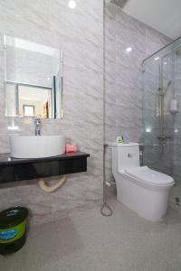La salle de bains est pourvue de toilettes, d'un lavabo et d'un miroir. dans l'établissement Relax hotel, à Quy Nhơn
