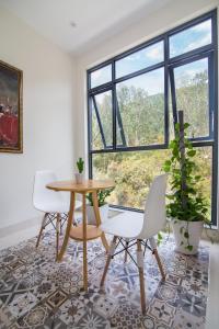 a living room with a table and two chairs and a window at Relax hotel in Quy Nhon