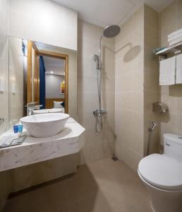 Un baño con lavabo, inodoro y ducha. en CODI SEA Hotel & Travel, en Da Nang