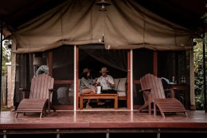 un grupo de personas sentadas en una mesa en una tienda en Honeyguide Tented Safari Camp - Khoka Moya, en Manyeleti Game Reserve