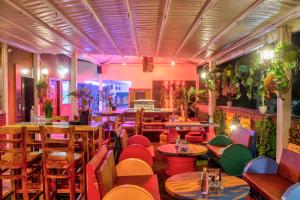 un restaurant avec des tables et des chaises en bois et un éclairage rose dans l'établissement HOTEL HILL VIEW, à Dehradun