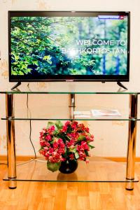 ステルリタマクにあるApartment Kvartirniy Vopros Hudaiberdina 126のテレビ画面、ガラステーブルの花瓶