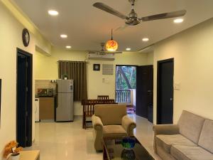 バガにあるAreia De Goa, Comfort Stay Apartment near Baga Beachのリビングルーム(ソファ、テーブル付)
