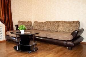 ステルリタマクにあるApartment Kvartirniy Vopros on Oktyabrya 8のリビングルーム(革張りのソファ、テーブル付)