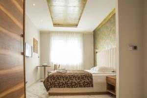 a hotel room with a bed and a window at Garni Boutique Hotel Arta in Novi Sad