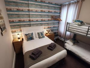 1 dormitorio con 2 camas y pared de madera en THE QUORN HOTEL, en Blackpool