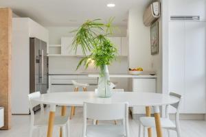 拉斯帕爾馬斯的住宿－Fantástico Apartamento cerca Playa，厨房以及带白色桌椅的用餐室。