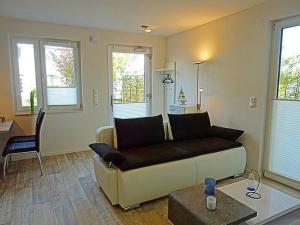 ein Wohnzimmer mit Sofa und Tisch in der Unterkunft Appartement Fienchen 1 SZ Terrasse by Unsere Urlaubszeit in Kellenhusen