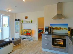 ein Wohnzimmer mit einer Küche mit einem Herd in der Unterkunft Appartement Fienchen 1 SZ Terrasse by Unsere Urlaubszeit in Kellenhusen