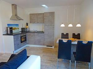 eine Küche mit Tisch und Stühlen in einem Zimmer in der Unterkunft Appartement Fienchen 1 SZ Terrasse by Unsere Urlaubszeit in Kellenhusen + 20 Fotos