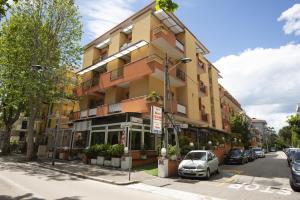 a building on a street with a car parked in front at Hotel Picador in Rimini