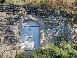 Una pared de piedra con una puerta azul. en Chambres d'hotes "Manoir Des Quatre Saisons" en La Turballe