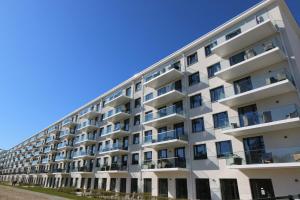 a white apartment building with a blue sky in the background at Haus Neues Prora 503 mit Meerblick in Binz