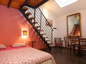 a bedroom with a bed and a spiral staircase at Le Jardin de Norah in Brulange