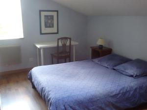 a bedroom with a bed and a desk and a chair at Le Jardin de Norah in Brulange