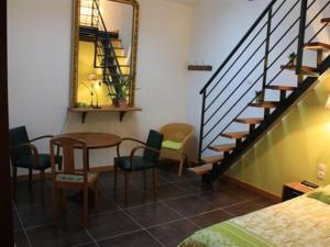 ein Zimmer mit einem Tisch, Stühlen und einer Treppe in der Unterkunft Le Jardin de Norah in Brulange