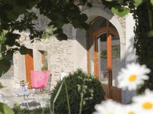une maison avec une chaise rose et une porte dans l'établissement Chambres d'hôtes-Les Chambres de Mado, à Margencel