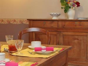 une table en bois avec une assiette de nourriture dans l'établissement Chambres d'hôtes-Les Chambres de Mado, à Margencel