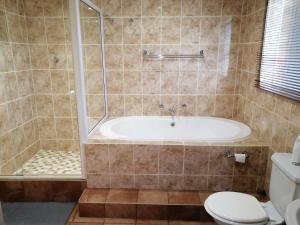 a bathroom with a tub and a toilet at BLS (Baie Lekker Slaap) in Bloemfontein