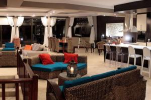a living room with couches and chairs and a kitchen at 4 Bedroom Luxury Home with View of the Ocean and Table Mountain in Cape Town