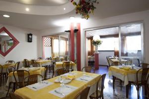 a restaurant with yellow tables and chairs and windows at Hotel Picador in Rimini