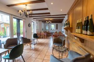 um restaurante com cadeiras, mesas e garrafas de vinho em Chambres d'Hôtes Le Domaine des Remparts em Sélestat