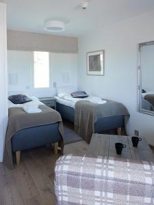 a room with two beds and a table at Woikoski Feeling - WHD Gård in Nurmaa