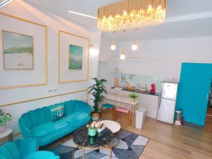 a living room with a blue couch and a table at 海角42號一館Villa包棟民宿 in Hengchun South Gate