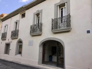 een wit gebouw met balkons en een ingang bij Clos de la Colombe in Pouzols
