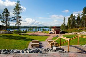 Nurmaa的住宿－Woikoski Feeling - WHD Gård，享有湖泊和建筑景致的公园