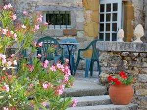 a patio with a table and chairs and flowers at Manoir de Rouessé in Laval