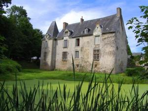 an old stone house in a field of grass at Manoir de Rouessé in Laval