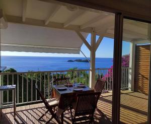 una mesa en una terraza con vistas al océano en Villa Azur B, en Bouillante