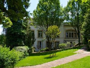una gran casa blanca con árboles en el patio en Le Clos Jeannon, en Nancy