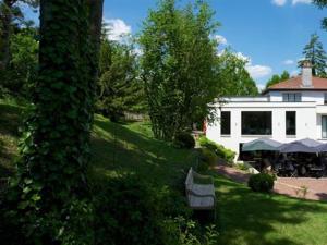 un patio con una casa blanca y un árbol en Le Clos Jeannon, en Nancy